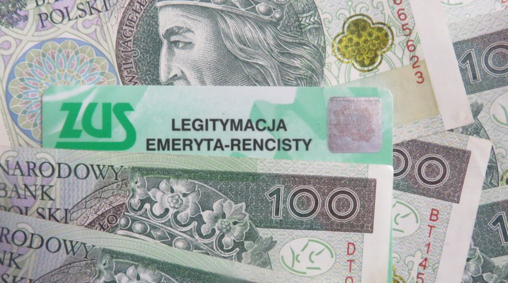 Legitymacja emeryta-rencisty leżąca pomiędzy banknotami 100 zł