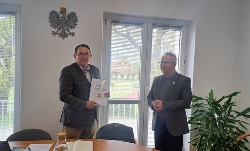 Wójt wręcza przewodniczącemu rady gminy ,,Raport o stanie gminy w 2025 roku"